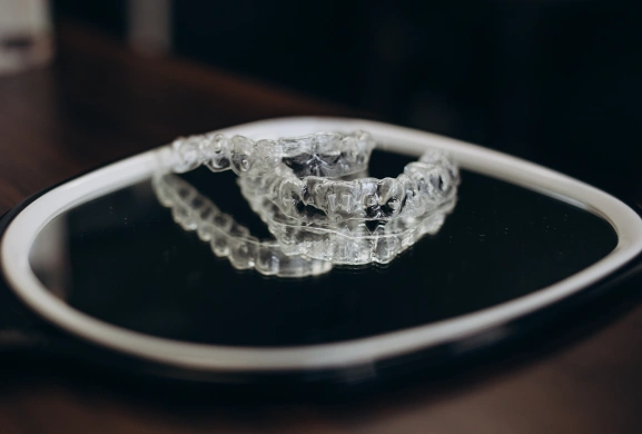 Clear aligner trays resting on a small mirror